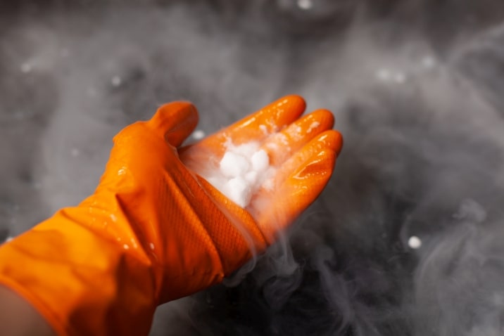 gloved hand holding dry ice