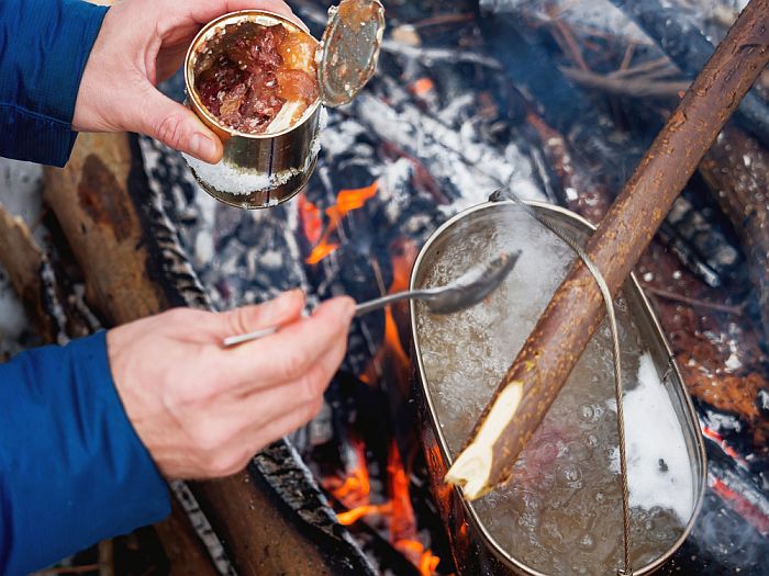 cooking canned food over a campfire