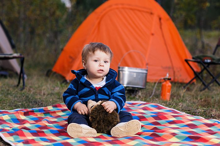 toddler sitting outside of tent
