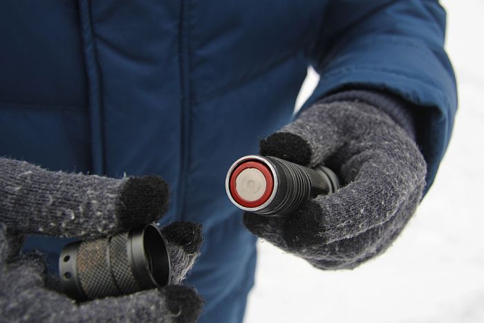 A man changing flashlight batteries.