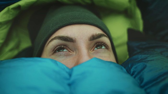 Cold woman in a sleeping bag.